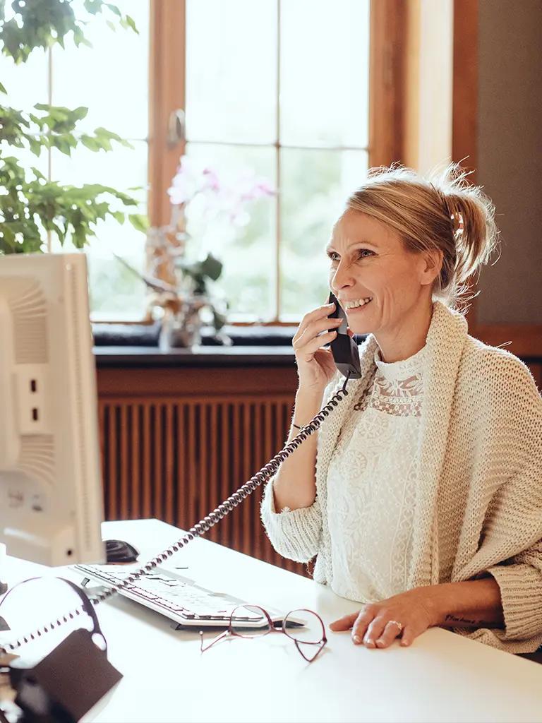 AdvoNeo Mitarbeiterin berät Mandanten am Telefon