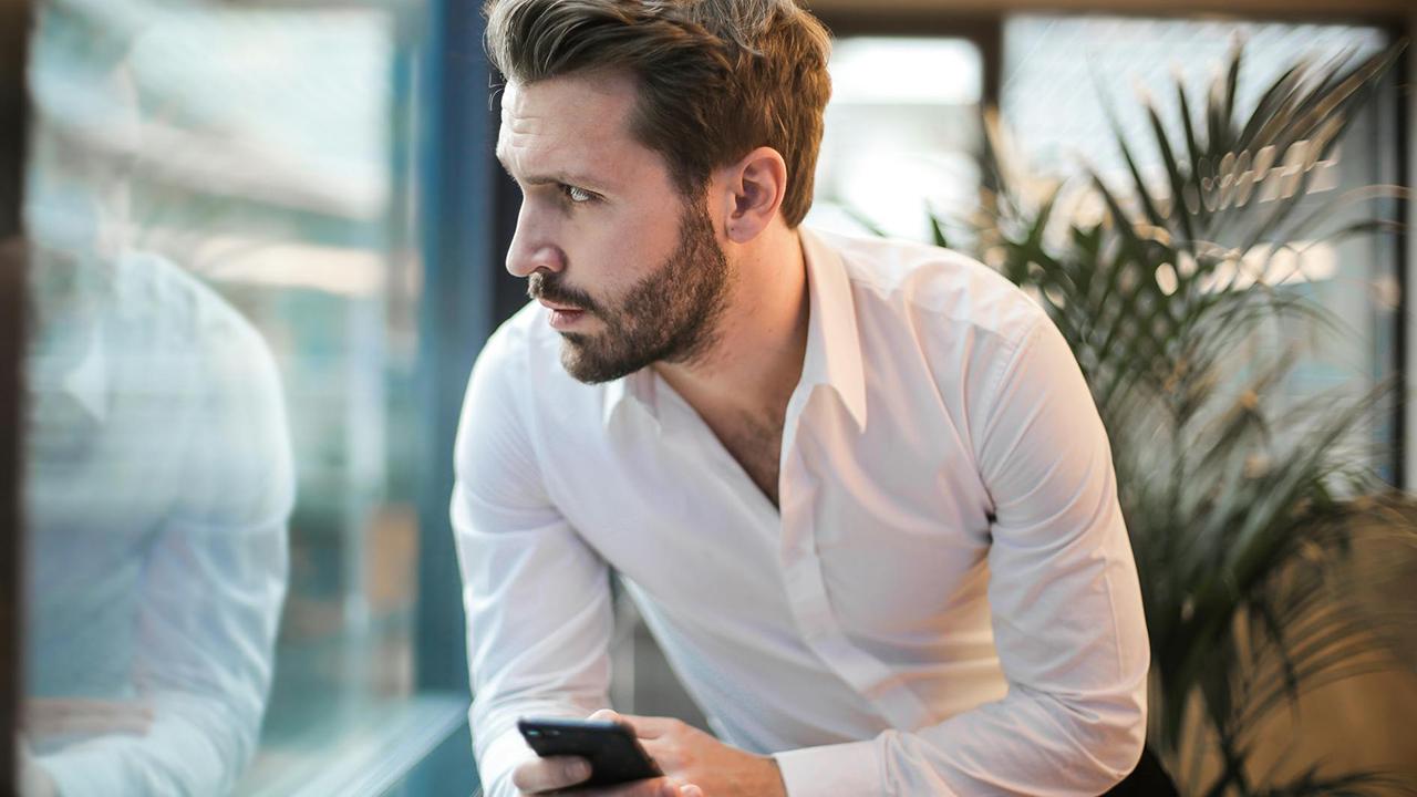 Gerichtsvollzieher Termin absgen - ratloser Mann mit Handy möchte Termin verschieben