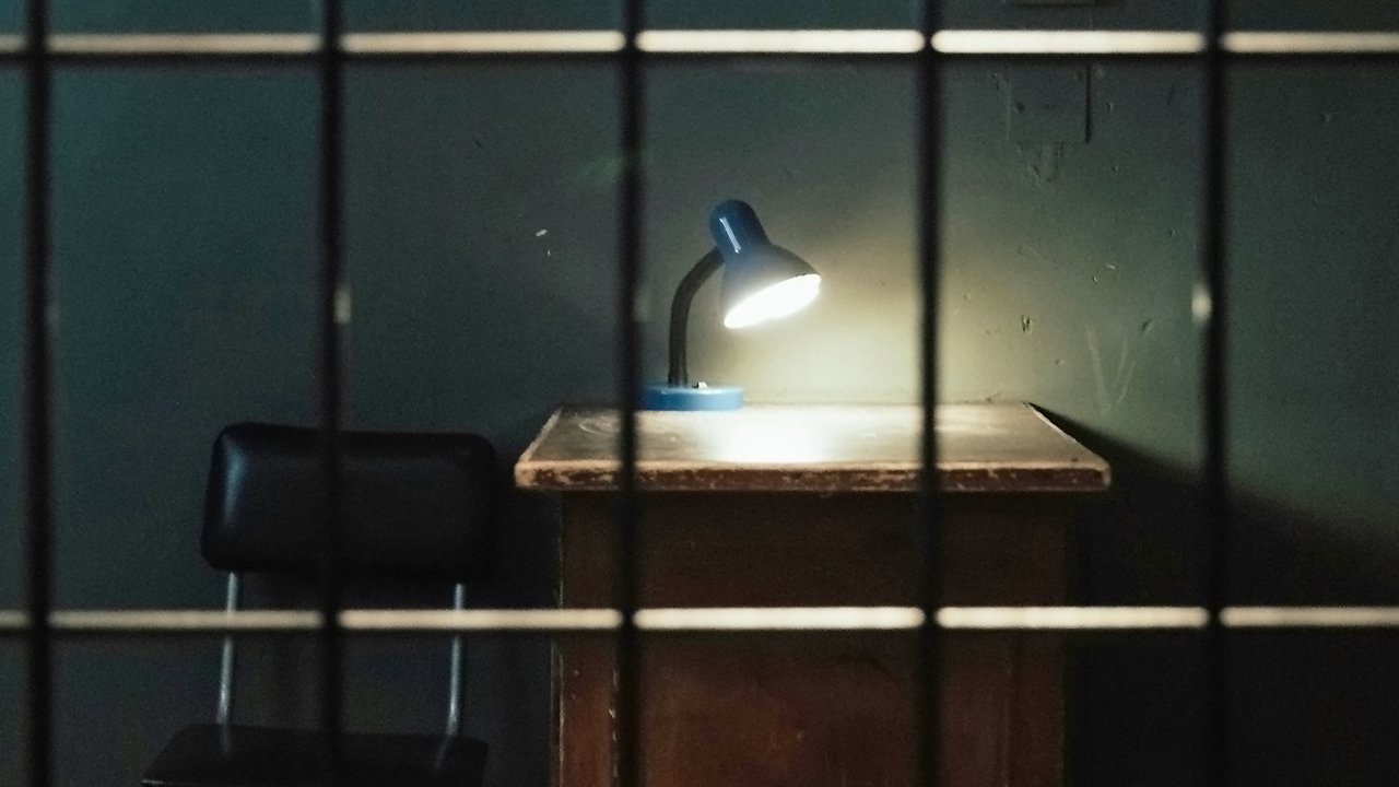 Haftbefehl wegen Schulden Titelbild: Gefängniszelle mit Lampe auf Tisch