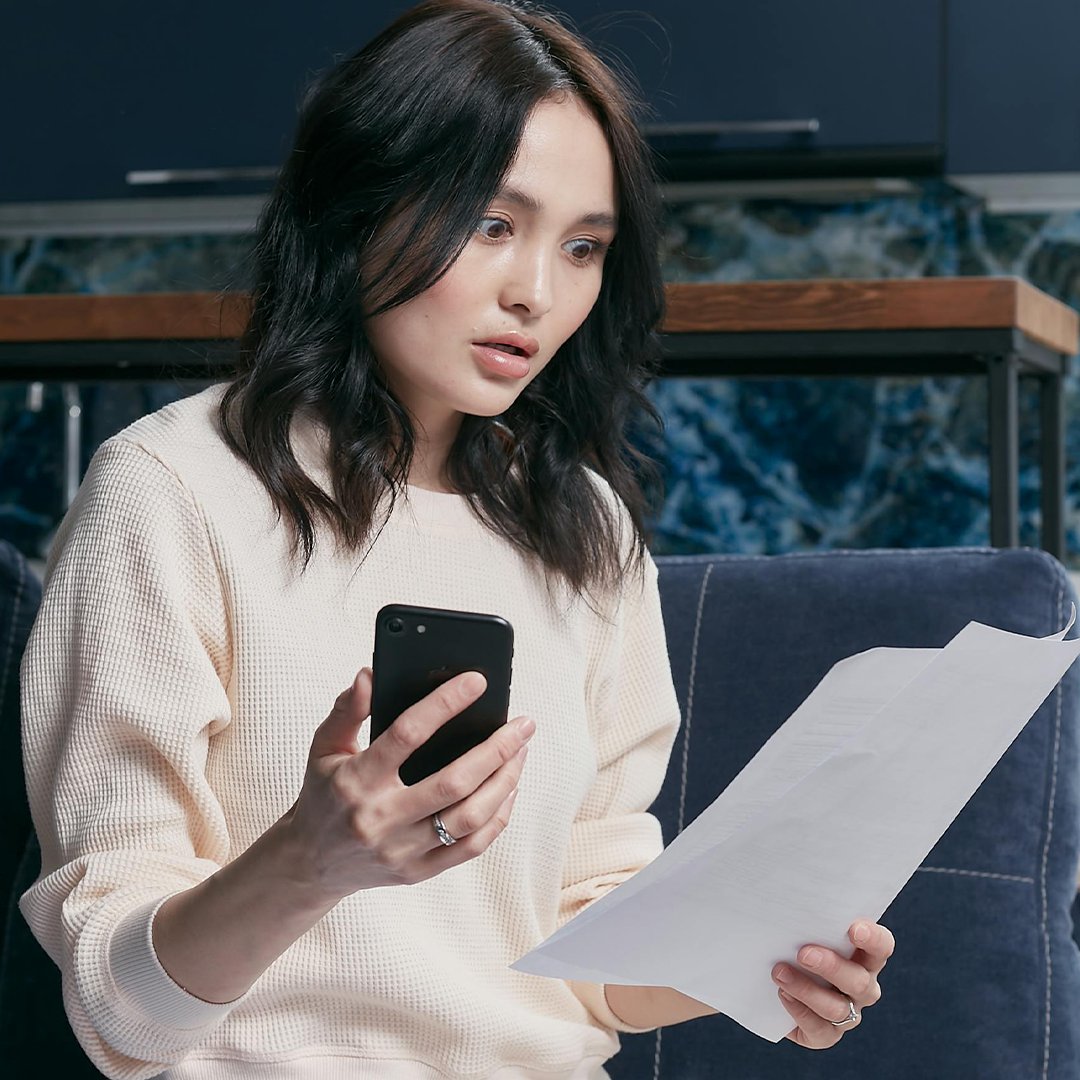 Schulden bei der Krankenkasse geschockte Frau mit Rechnung