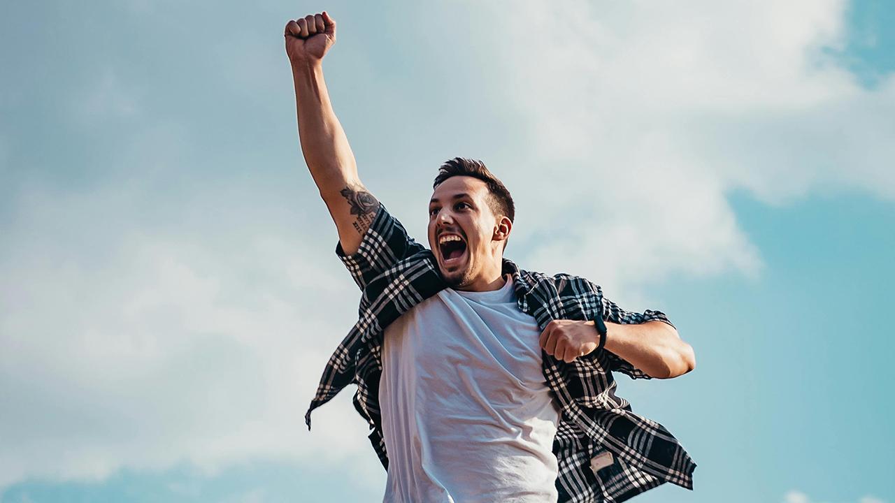 Lottogewinn vor Freude springender Mann