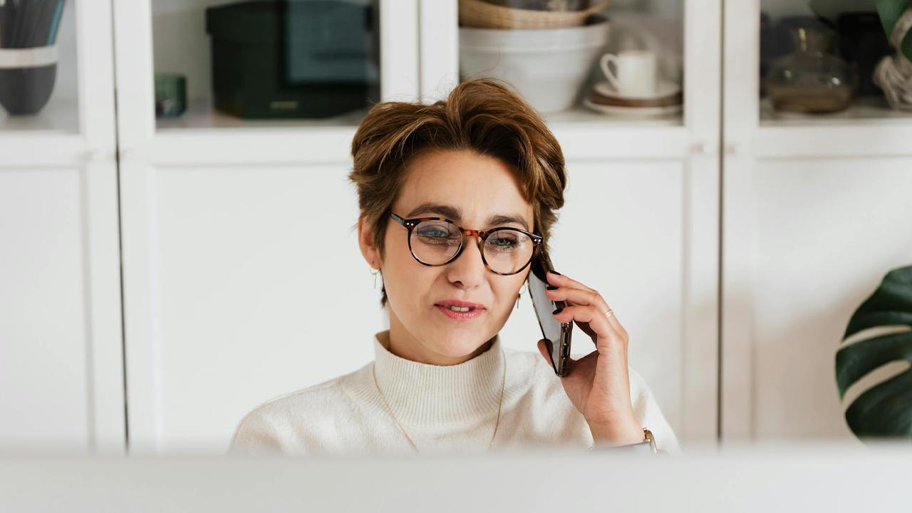 besorgte Frau telefoniert wegen Schulden bei der Krankenkasse
