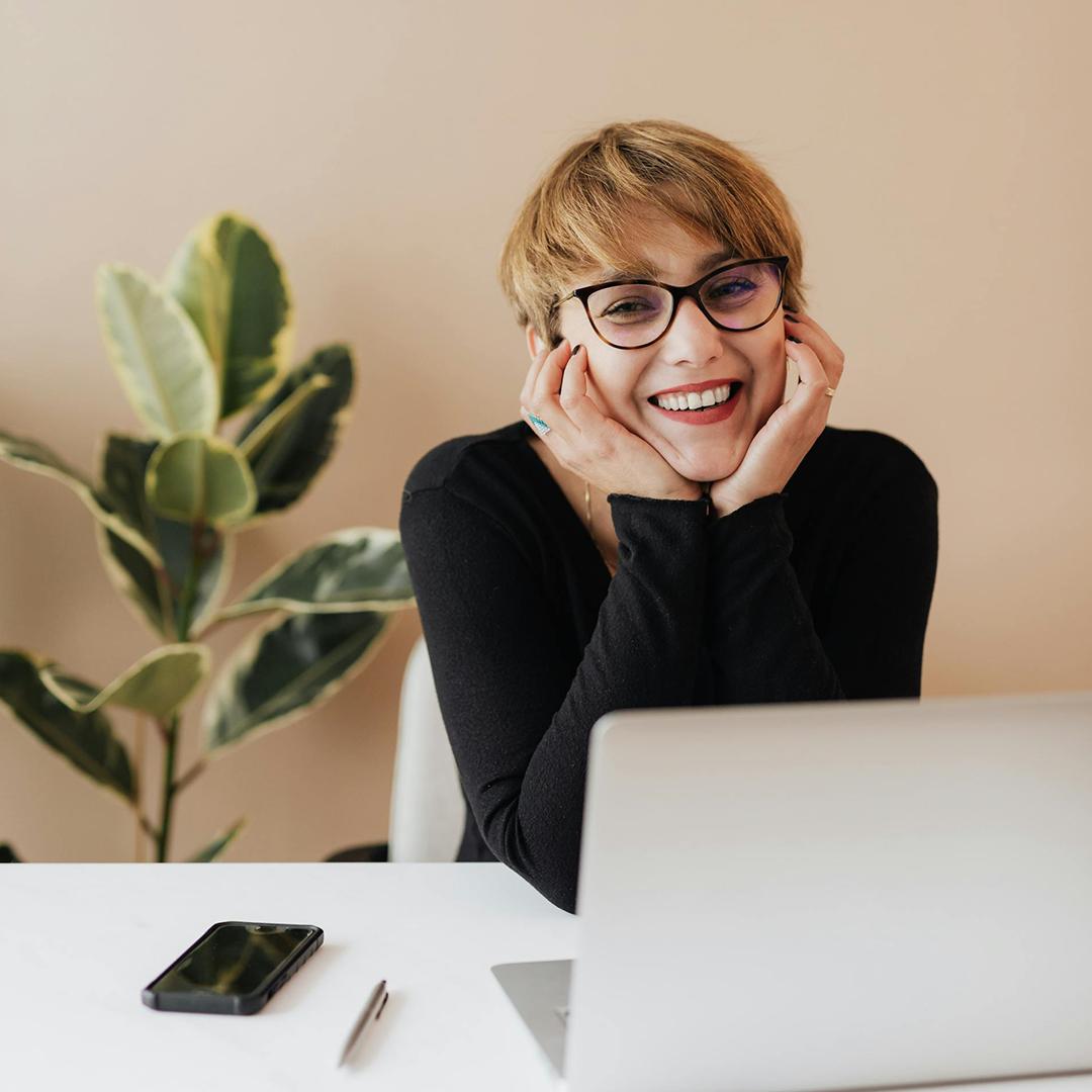Schulden vermeiden lächelnde Frau Onlinebanking Laptop