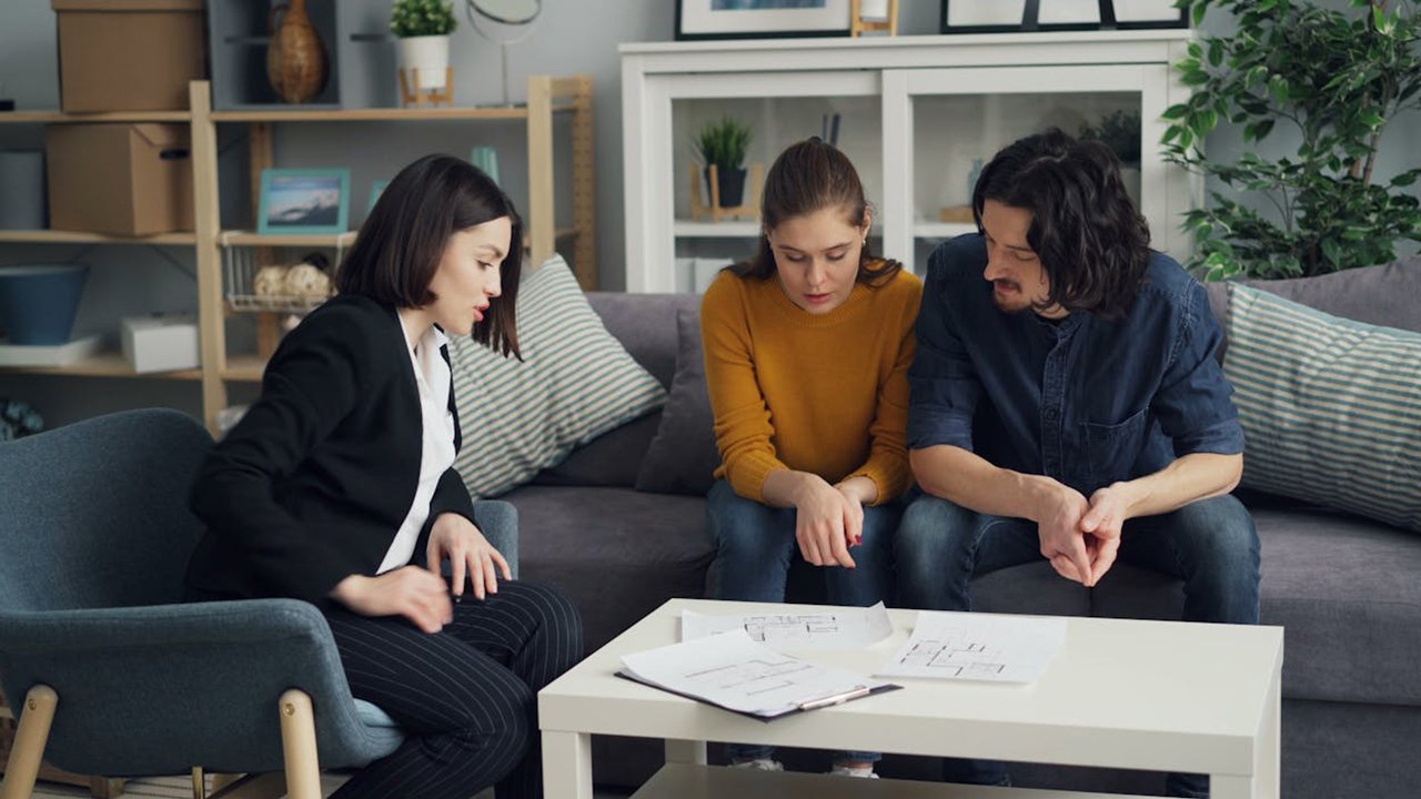 Mietschulden 3 Personen im Beratungsgespräch in einer Wohnung, Hilfe bei Schulden