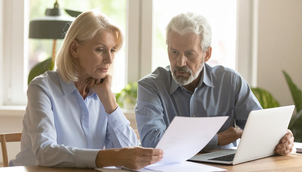 Paar prüft Finanzunterlagen – Symbolbild für Schuldenbereinigung und Insolvenzverfahren bei natürlichen und juristischen Personen. AdvoNeo Schuldnerberatung