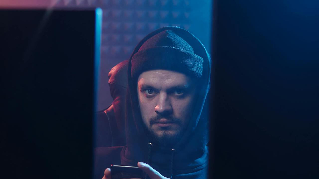 Online Betrug Mahnung E-Mail Betrüger mit Smartphone