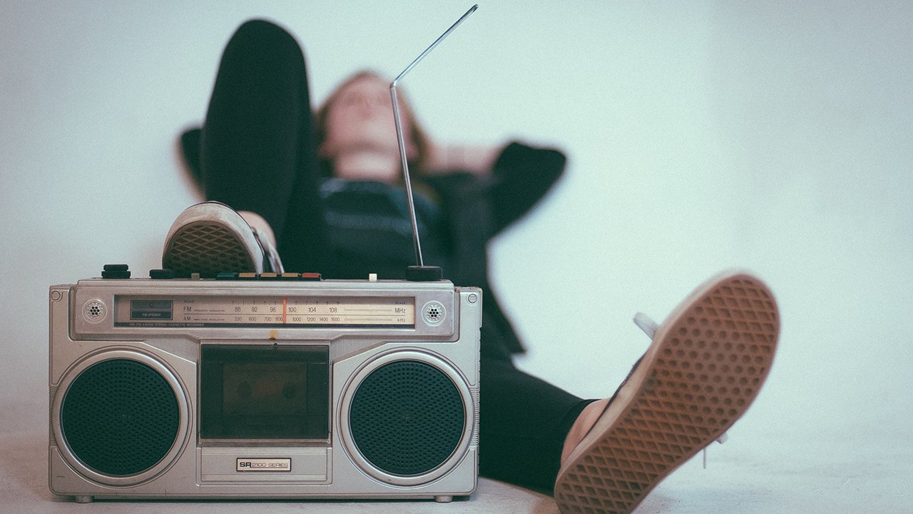Rundfunkbeitrag nicht bezahlen (Symbolbild): liegende Person mit Radio